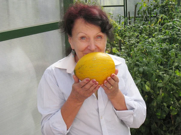 Vrouw met rijpe gele tuin meloen — Stockfoto