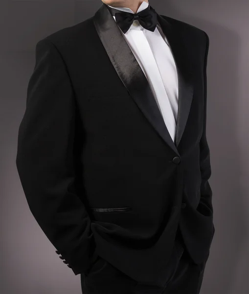 Man in classic tuxedo on abstract dark grey background.photograp — Stock Photo, Image