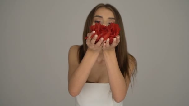 Belle femme souriante avec des pétales de rose tombants — Video