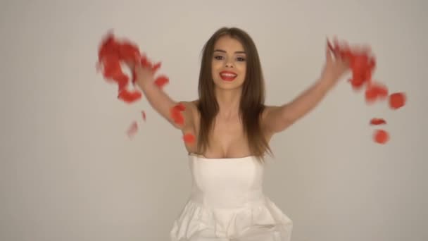 Vacker kvinna ler med fallande rosenblad — Stockvideo