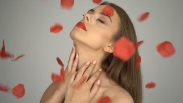 Bella donna sorridente con petali di rosa cadenti — Video Stock