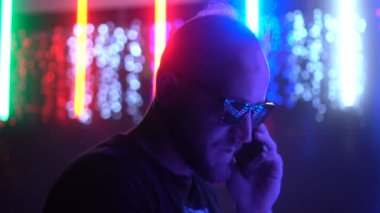 Cep telefonu tutan güneş gözlüğü, giyen genç adam, 