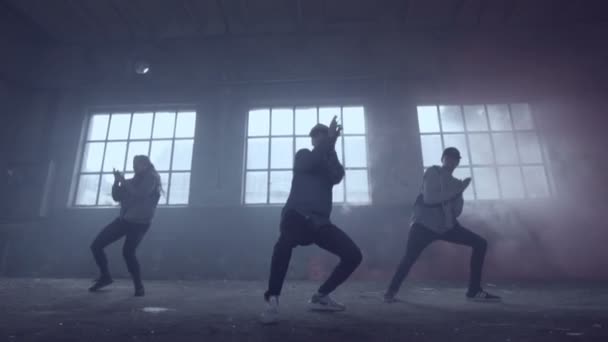 Video van actieve jonge groep dansen choreografie in een verlaten gebouw met rokerige achtergrond in slow motion. — Stockvideo