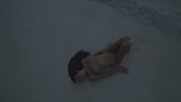 Asian beautiful woman in crochet bikini lying on the beach. Video of sexy girl lying on the sand and moving sensually in slow motion. — Stock Video