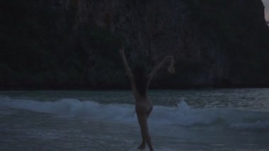 Sahilde tığ bikini dans Asya güzel kadın. Elinde sütyen ile plajda dans seksi kız Video - yavaş hareket.