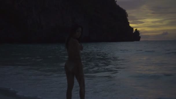 Asiatique belle femme en bikini crochet marche sur la plage. Vidéo de fille sexy marchant sur la plage avec soutien-gorge dans sa main .