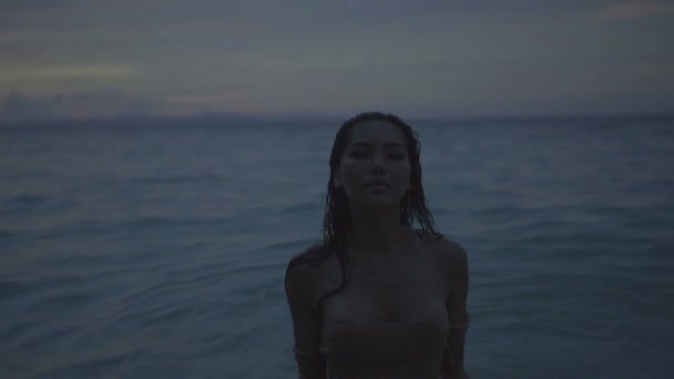 Asiatische schöne sinnliche Frau im gehäkelten Bikini, die im Meer spazieren geht. Video von sexy Mädchen, die in Zeitlupe im Meer spazieren. — Stockvideo