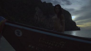 Teknede tığ işi bikini Asya güzel şehvetli kadın. Yavaş çekimde gün batımında teknede duran seksi gülümseyen kız Video.