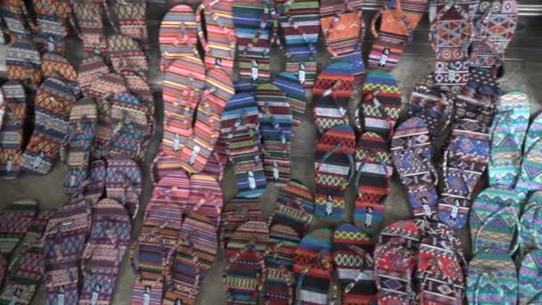 Θηλυκό προσπαθεί με σαγιονάρες σε μια αγορά οδών στην Μπανγκόκ. Ποικιλία από πολύχρωμες flip flops στο πραγματοποιείται υπαίθριο παζάρι. — Αρχείο Βίντεο