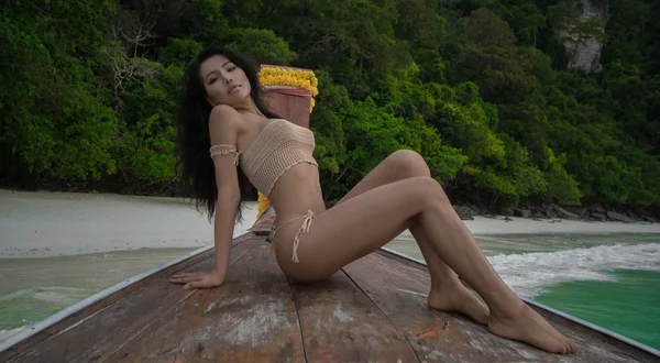 Азиатская красивая чувственная женщина в вязаном бикини на лодке. Сексуальная девушка лежит на бантике и смотрит в камеру . — стоковое фото