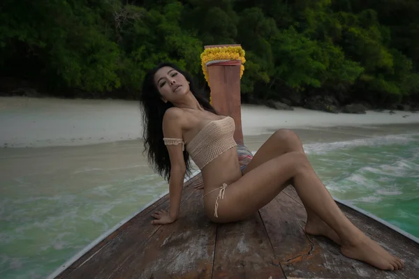 Mujer sensual hermosa asiática en bikini de ganchillo en el barco. Sexy chica acostada en un arco y mirando a la cámara . — Foto de Stock