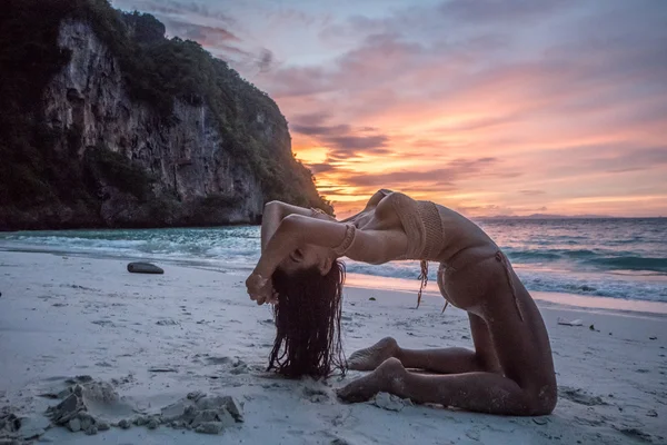 惊人的日落时分在沙滩上摆姿势的钩针比基尼亚洲美丽的女人. — 图库照片