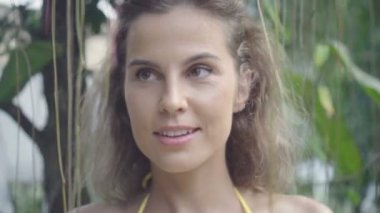 Güzel genç mutlu kadın bikini giyen ürpertici ler arasında yürüyüş ve yavaş hareket onu tatil sırasında gülümseyerek.