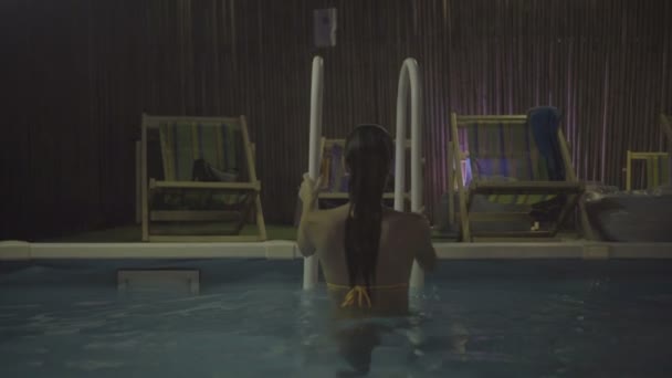 Sexy giovane donna che tiene i corrimano mentre esce dalla piscina . — Video Stock