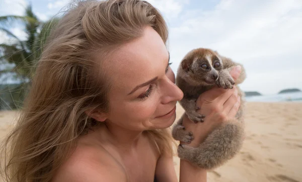 Loris lento en manos de mujeres aisladas en la playa . — Foto de Stock