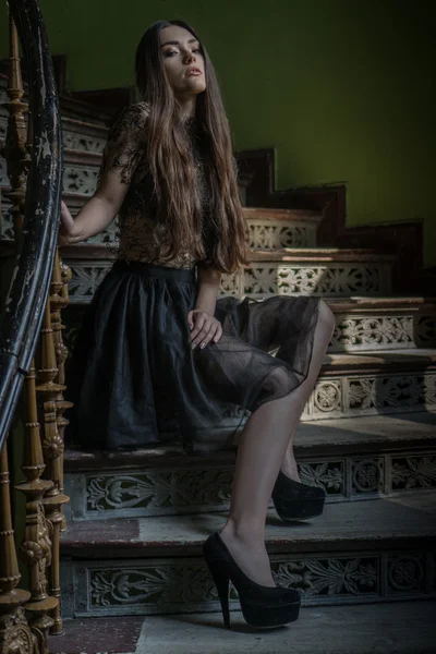 Woman wearing dress sitting on the staircase - horror scene — Stock Photo, Image