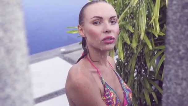 Face close up de mulher loira sexy de biquíni tomando banho ao ar livre na piscina rodeada de jardim tropical - vídeo em câmera lenta . — Vídeo de Stock