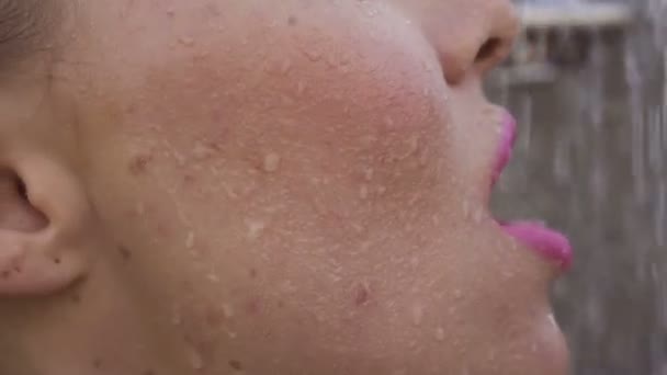 Faccia da vicino della donna bionda sexy sorridente con i denti bretelle indossare canotta trasparente bianco prendendo doccia all'aperto sulla piscina sul tetto - video al rallentatore . — Video Stock