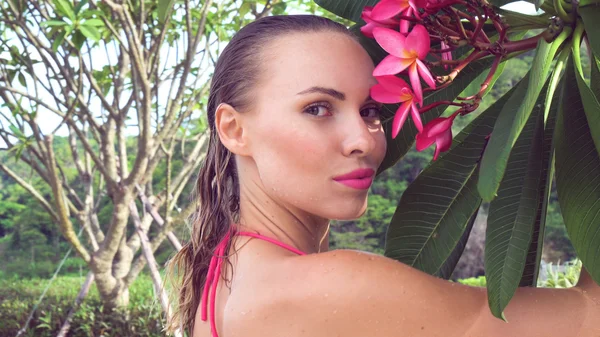 Close up de sexy jovem mulher vestindo biquíni com cabelo molhado e flor de árvore no telhado em um dia ensolarado — Fotografia de Stock