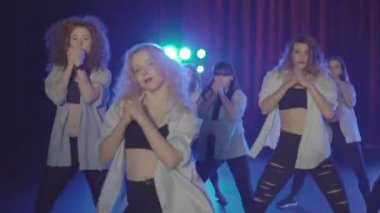 Mavi ışıklar ve duman ile karanlık bir sahnede güzel kadın grubun Closeup dans performansı