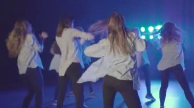 Mavi ışıklar ve duman ile karanlık bir sahnede güzel kadın grubun Closeup dans performansı