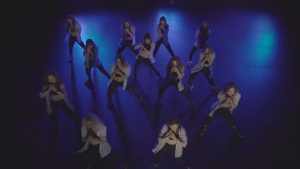Vue du dessus d'un joli groupe féminin dansant sur une scène sombre avec des lumières bleues et de la fumée — Video