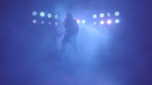 Silhouette de femme solo freestyle performance danse pieds nus sur une scène sombre avec des lumières bleues et de la fumée — Video