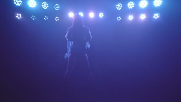 Silhouette de femme solo freestyle performance danse pieds nus sur une scène sombre avec des lumières bleues et de la fumée — Video