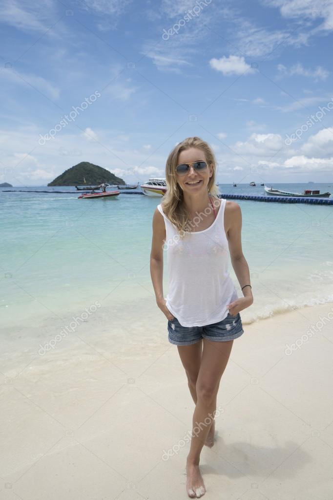 Smiling pretty blonde wearing jeans shorts, white t-shirt and ...