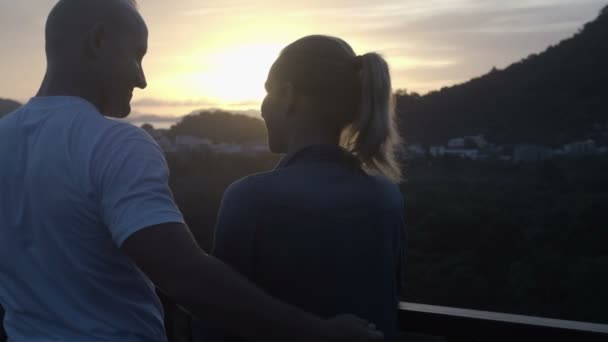 Back view of happy caucasian couple in love standing on a rooftop, smiling and watching beautiful sunrise — Stock Video