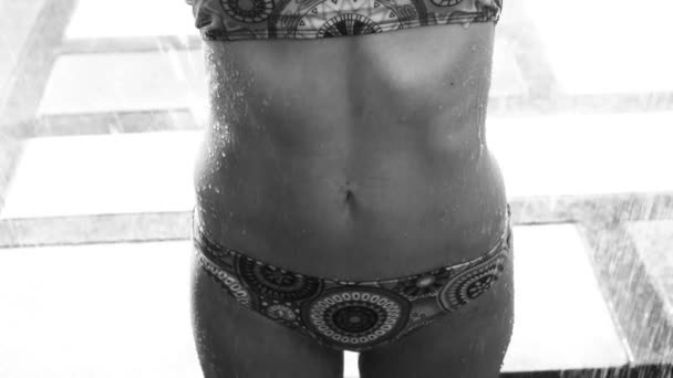 Gros plan de femmes estomac portant un bikini sous la douche extérieure - vidéo en noir et blanc — Video