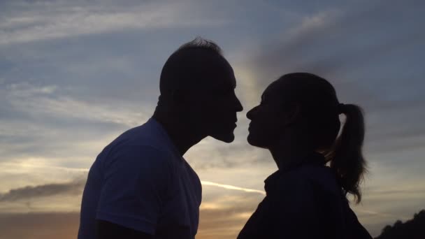 Vista posterior de la feliz pareja caucásica en el amor besándose mientras está de pie en una azotea y viendo el hermoso amanecer — Vídeo de stock