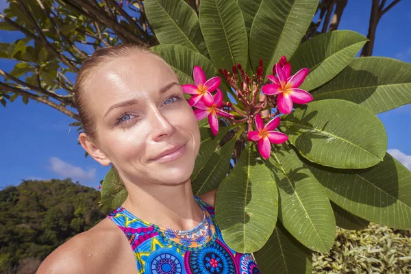 Primeros planos de una hermosa mujer rubia en bikini con flor de árbol en la azotea en un día soleado — Foto de Stock