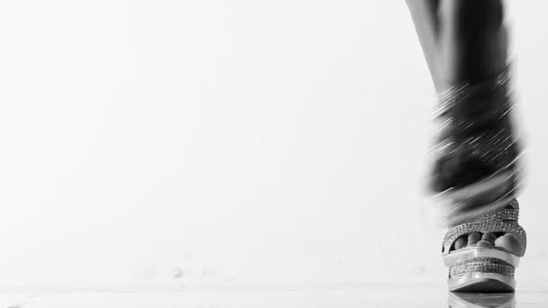 Sexy woman dancing in sparkly silver high heels over white background - shoes and legs closeup — Stock Video