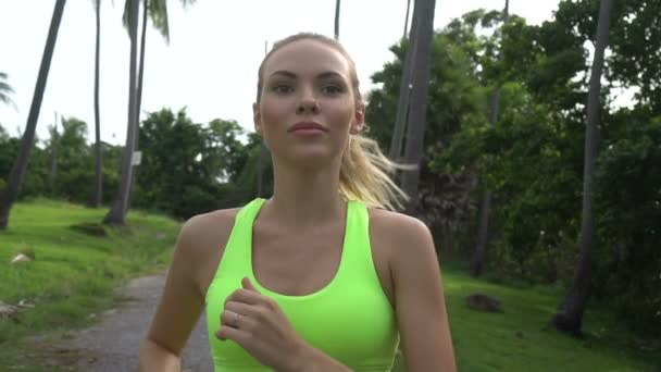 Fitness bella donna bionda nel giardino delle palme tropicali durante la bella giornata estiva — Video Stock