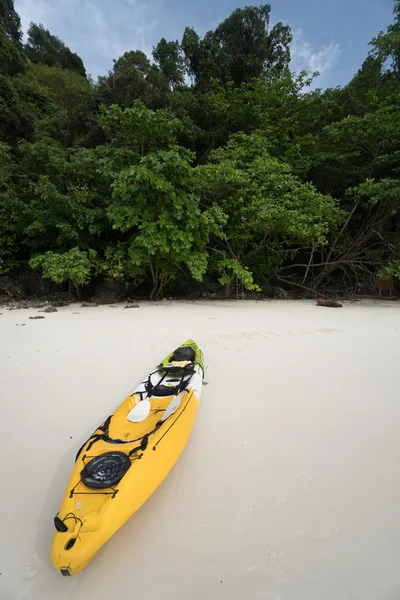 A yellow kayak on a tropical beach over green trees background — Stock Photo, Image