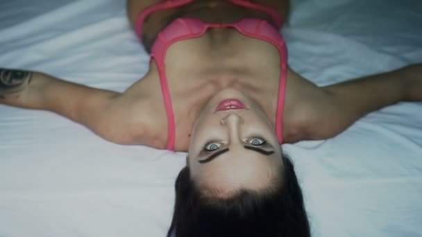 Närbild porträtt av ung vacker brunett kvinna som bär Rosa underkläder leende och beundra morgon liggande på sängen — Stockvideo