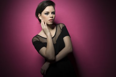 Pembe arka plan üzerinde izole siyah zarif gömlek giyen genç güzel esmer kız Güzellik portresi