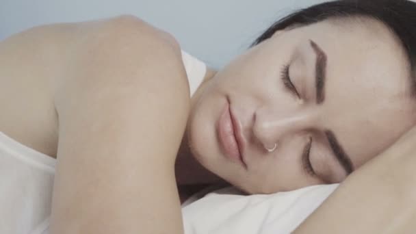 Linda jovem morena acordando pacificamente enquanto deitada em sua cama — Vídeo de Stock