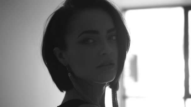 Fekete-fehér közeli portréja gyönyörű fiatal nő, mosolygós visel elegáns ruha és fülbevaló - a video-ban lassú mozgás — Stock videók