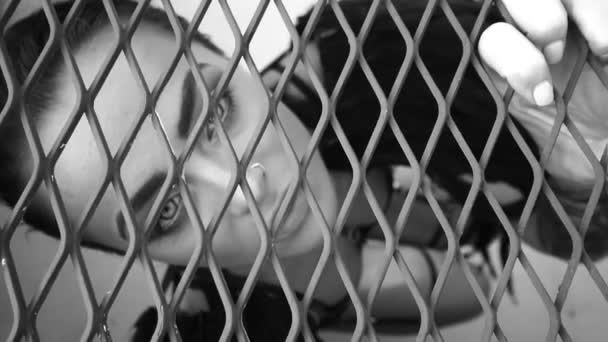 Nahaufnahme Porträt einer sinnlich schönen Engelsfrau, die im Käfig gefangen nach oben schaut - Schwarz-Weiß-Video — Stockvideo