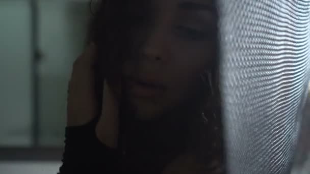 Gros plan portrait de belle femme brune posant et regardant dans la caméra sur fond sombre 