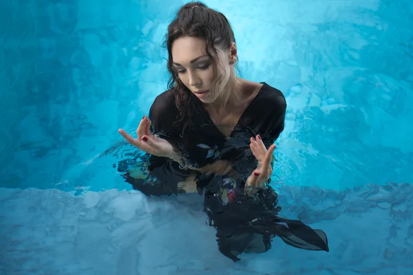 Top vista foto de bela mulher morena vestindo túnica preta em pé na piscina — Fotografia de Stock