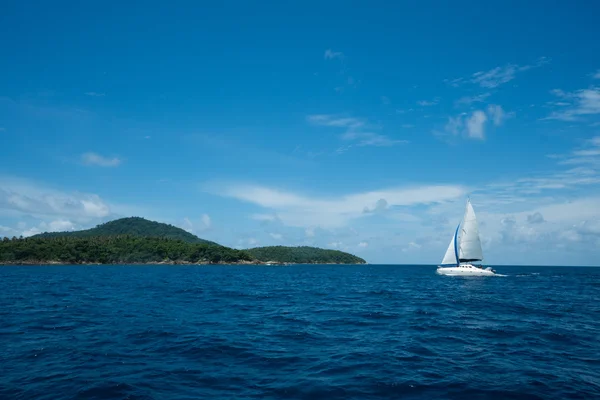 白いヨットの近くの緑の島の青い海でセーリングと美しい海の風景 — ストック写真