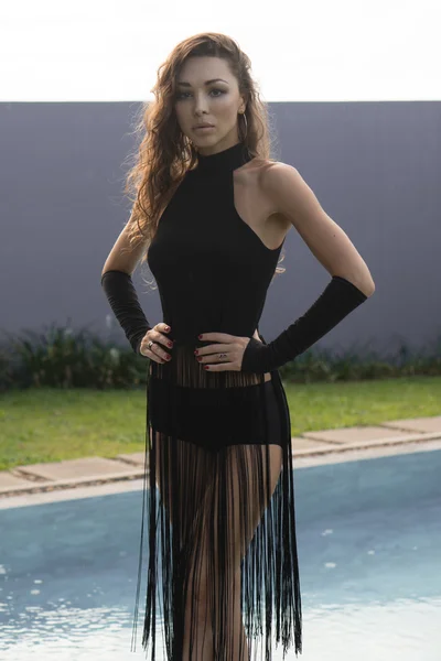 Foto von hinreißenden Mode Brünette in elegantem Outfit Blick in die Kamera neben Schwimmbad in luxuriöse Villa — Stockfoto