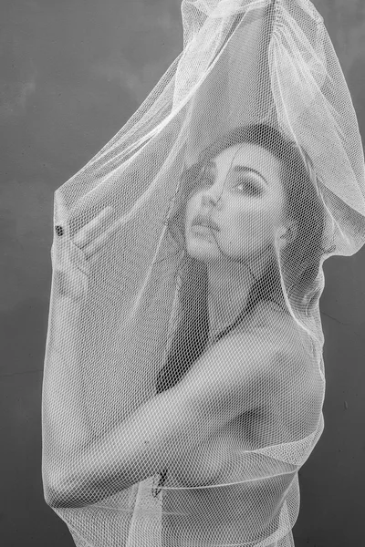 Black and white closeup portrait photo of sensual beautiful brunette woman trapped in the fishnet — Stock Photo, Image