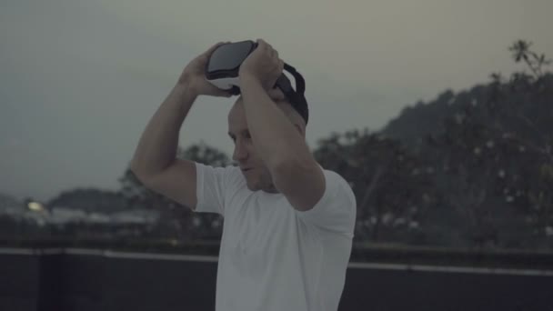 Ο άνθρωπος χρησιμοποιεί ένα γυαλιά εικονικής πραγματικότητας στη στέγη — Αρχείο Βίντεο