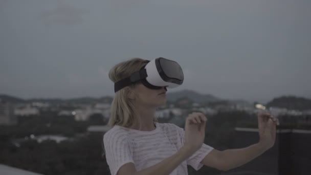 이른 저녁-360 슬로우 모션에서 비디오 동안 지붕에 서 있는 동안 가상 현실 안경 재미 여자 — 비디오