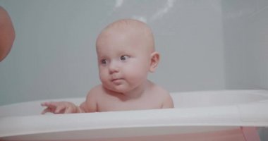 Küçük şirin bebek banyo yapıyor.