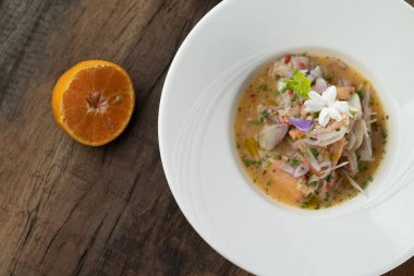 Karides, beyaz levrek, mürekkep balığı, portakal soslu somon, ahşap masada izole edilmiş.